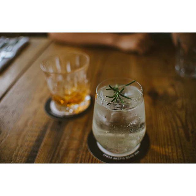 Two cocktail glasses on a wooden table create a relaxing and elegant mood with shallow depth of field.