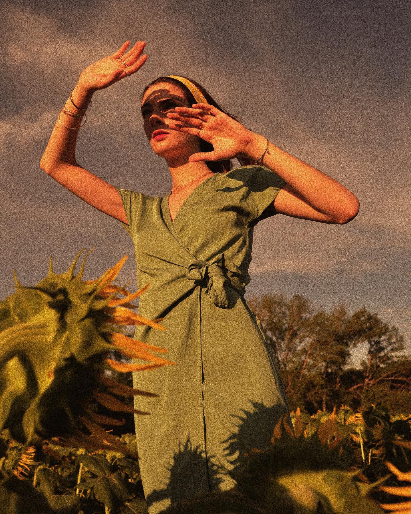 Woman In Sunflower Field Shielding Eyes From Sun