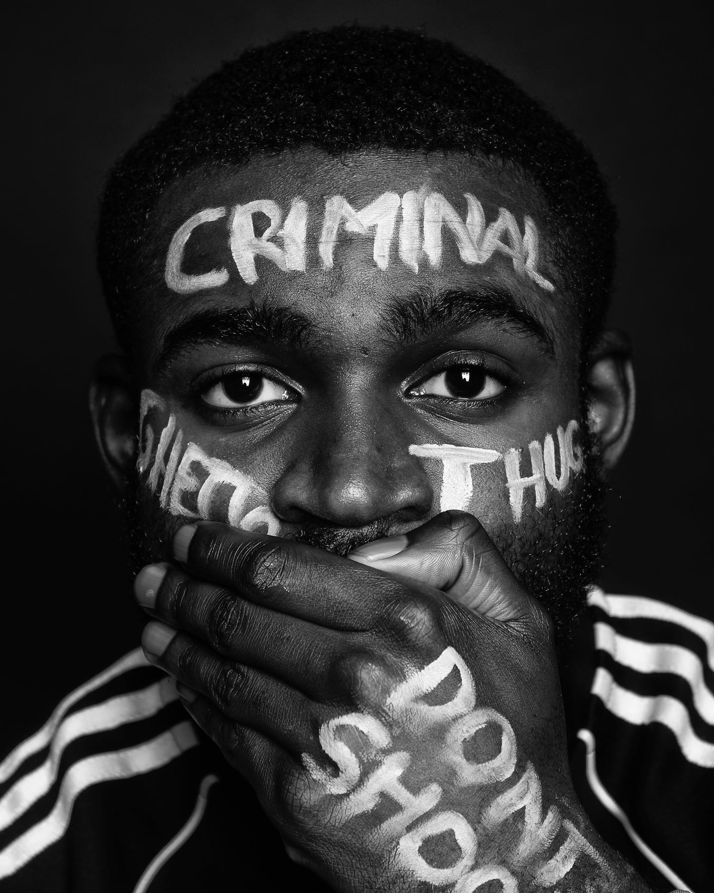 A man in black and white with face paint conveys a powerful message of social justice and equality.