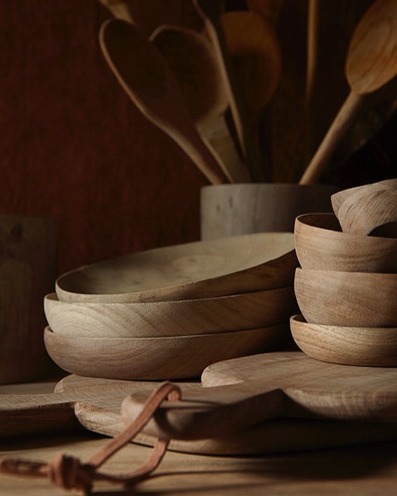 A warm, inviting image of wooden bowls, spoons, and a cutting board, ideal for kitchenware or sustainable living concepts.