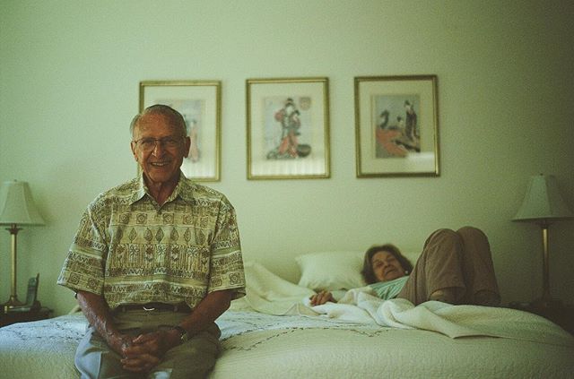 An elderly couple relaxes in their bedroom, creating a heartwarming and nostalgic scene.