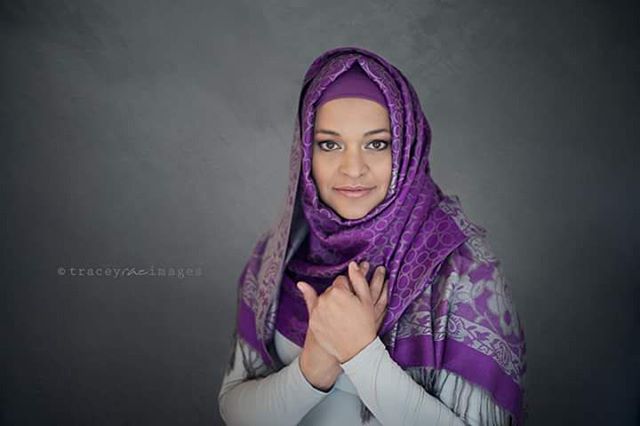 A portrait of a woman wearing a purple hijab, exuding a sense of calm and cultural identity.