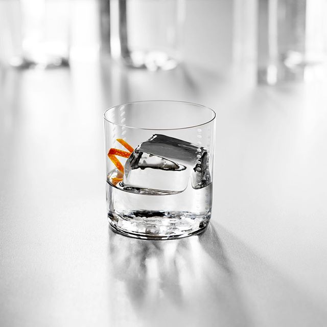 A refreshing cocktail with ice and orange peel, perfect for social media or advertising campaigns. Enjoy a calming moment.