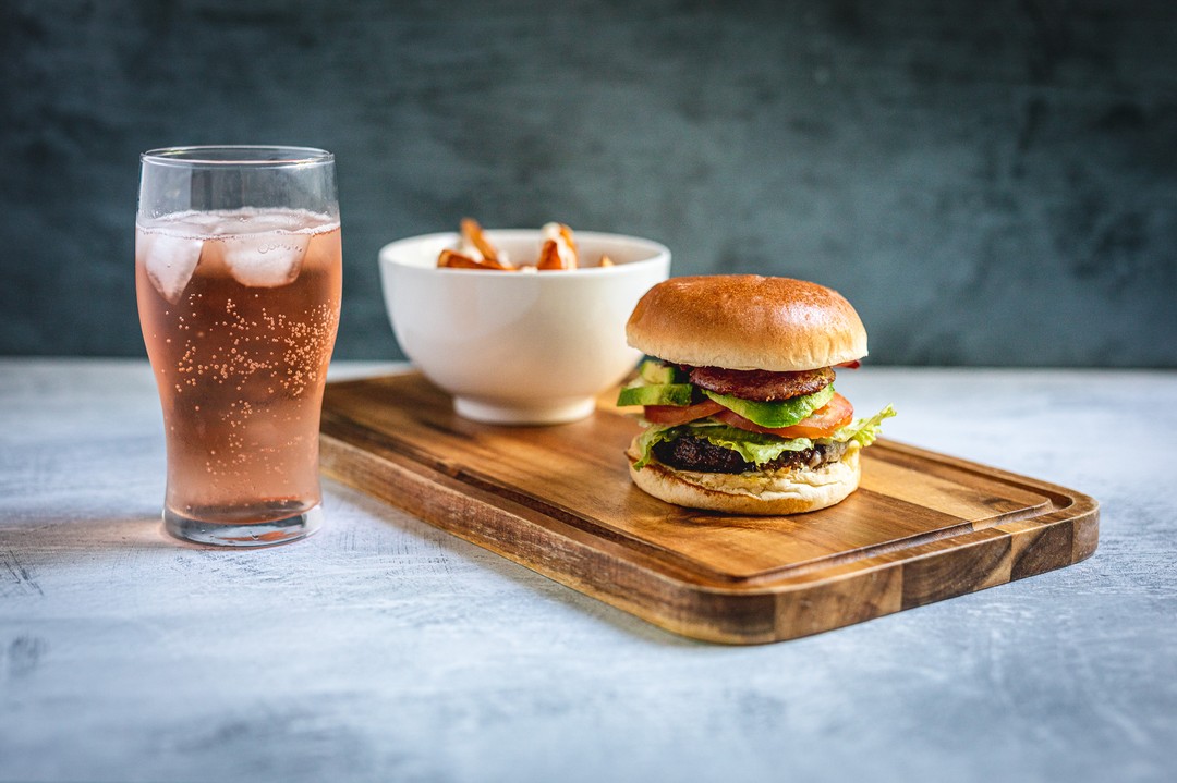 A delicious burger, french fries and a refreshing drink create a simple and satisfying meal.