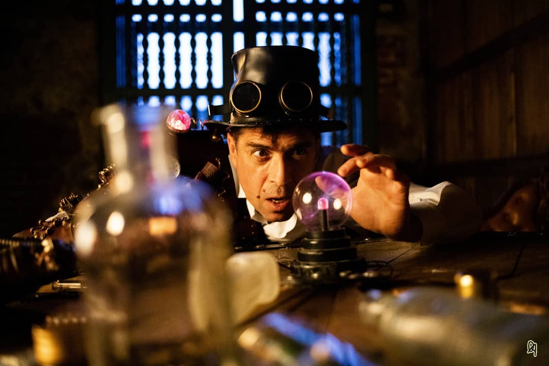 A steampunk scientist examines a glowing crystal ball in his laboratory, blending retro aesthetics with a sense of mystery.