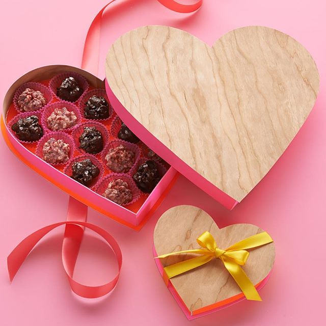 Heart-shaped boxes of chocolates on a pink background, perfect for Valentine's Day or a sweet gift.
