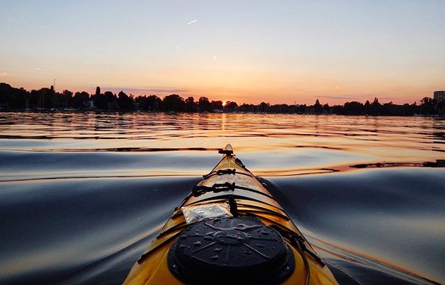 A yellow kayak on a calm lake at sunset provides a tranquil and adventurous outdoor scene.