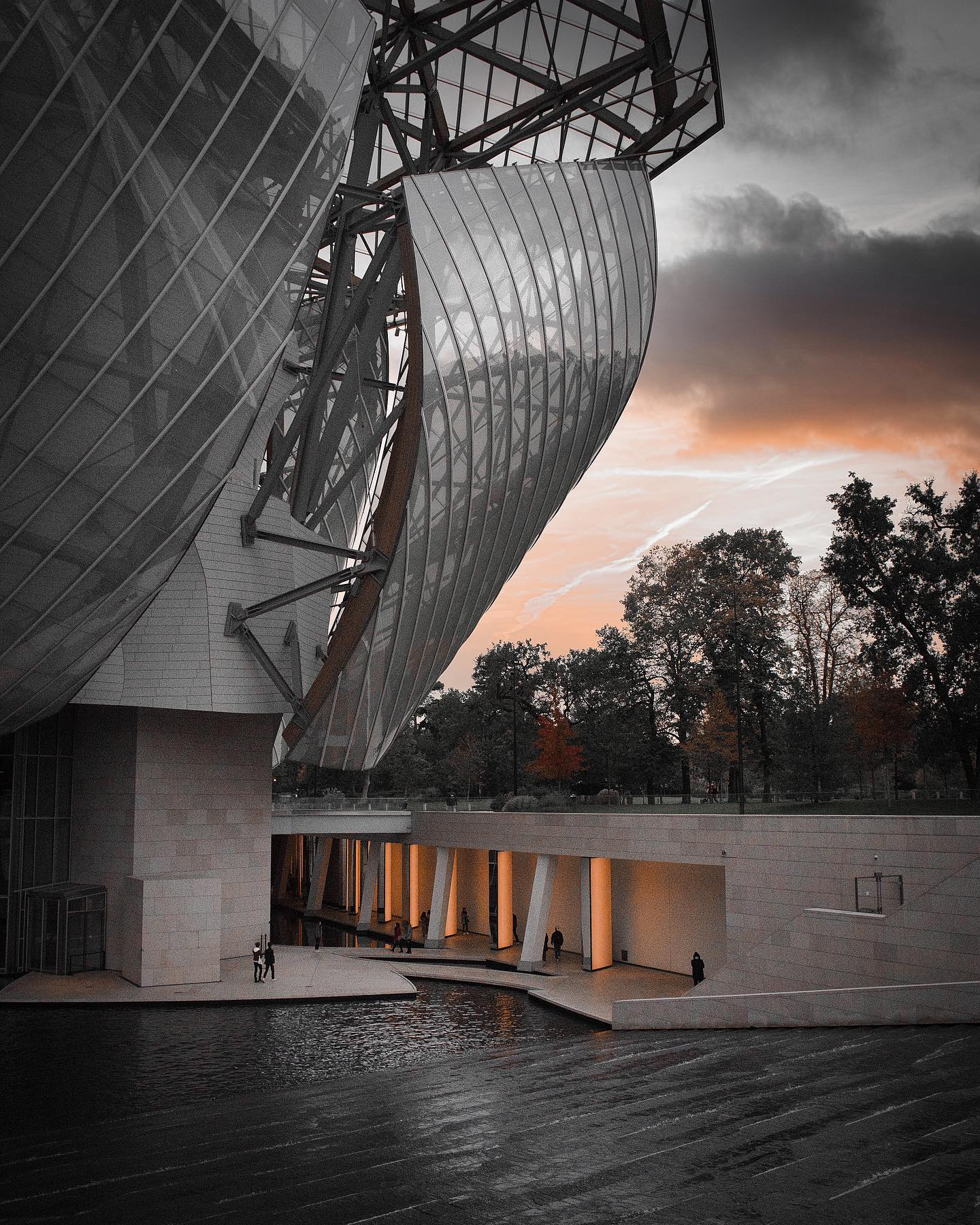 A modern architectural building with unique design elements is reflected in the surrounding water.