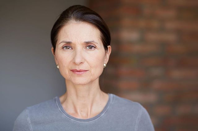 A portrait of a middle-aged woman with a serious expression, ideal for skincare or beauty advertising.