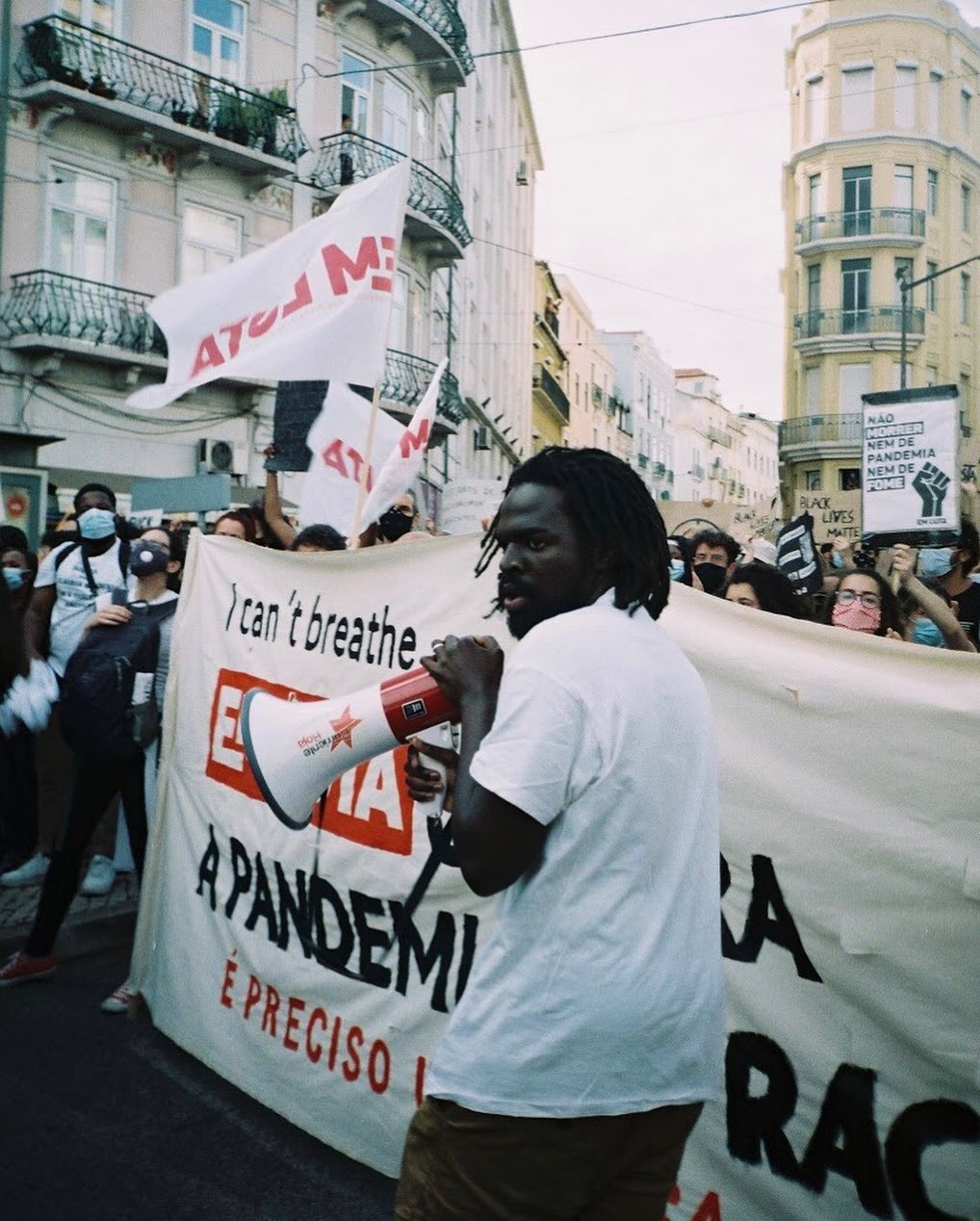 A man speaks through a megaphone during a Black Lives Matter protest on a city street.
