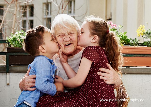 A heartwarming image of a grandmother being kissed by her grandchildren, conveying love and family connections.