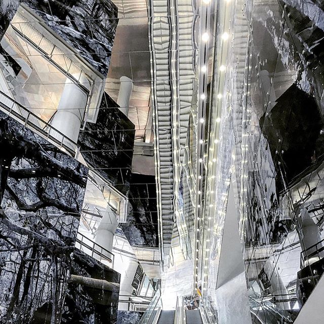 Abstract view of escalators and modern interior architecture, a visually striking blend of geometric patterns and monochrome tones.