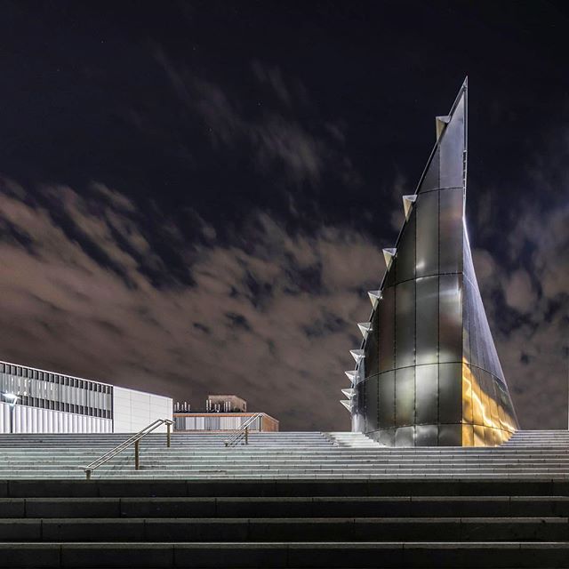 Modern architecture glows against a night sky, showcasing sleek lines and urban sophistication.