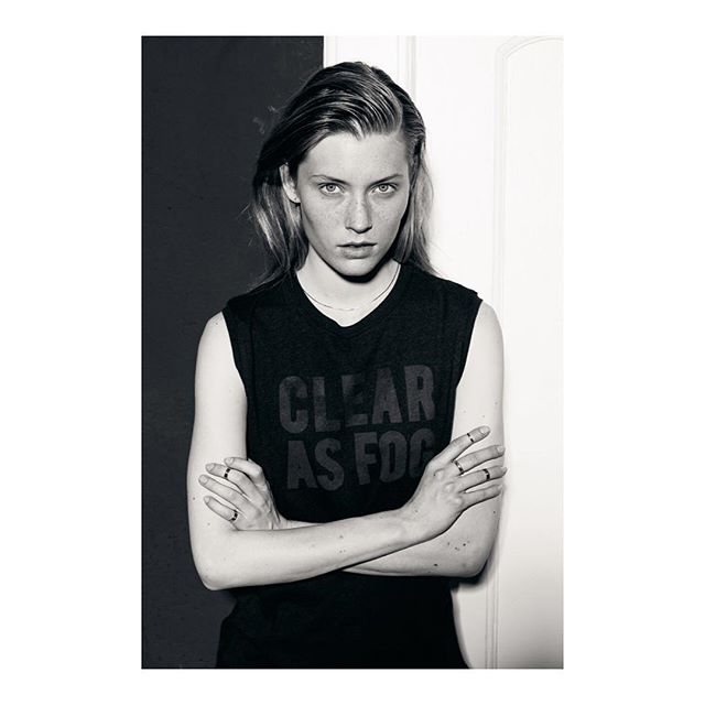 A young woman poses with confidence in a black and white editorial style photograph.