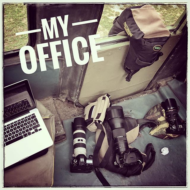 Mobile office setup with laptop, camera gear inside a vehicle during travel, ideal for content creation on the move.