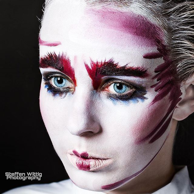 A woman with striking makeup poses for an artistic beauty shot.