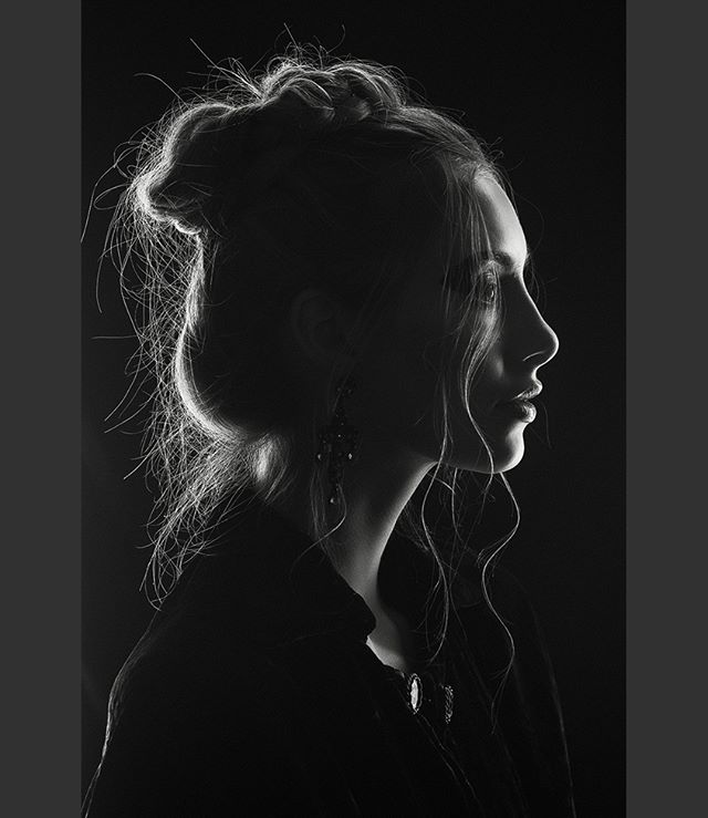 Elegant monochrome portrait of a woman in profile with soft rim lighting and a dreamy, contemplative mood. Perfect for editorial use.