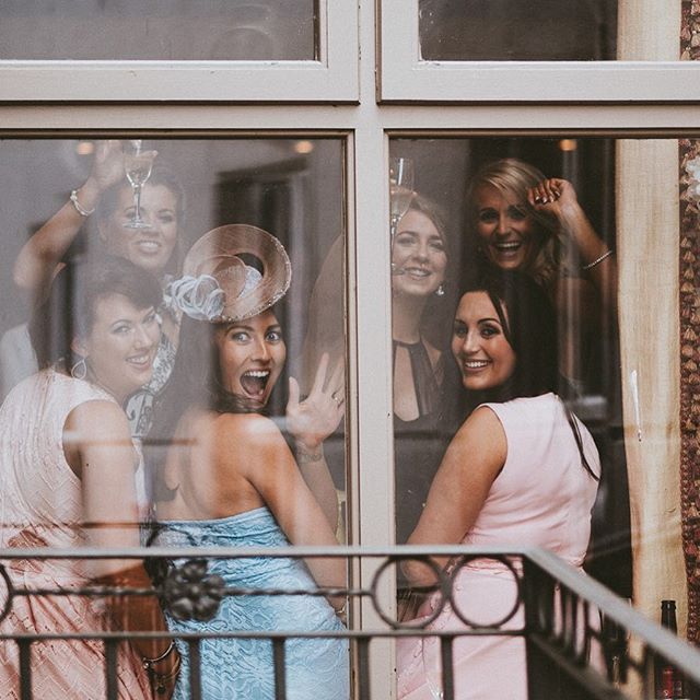 A group of women celebrating, looking through a window.