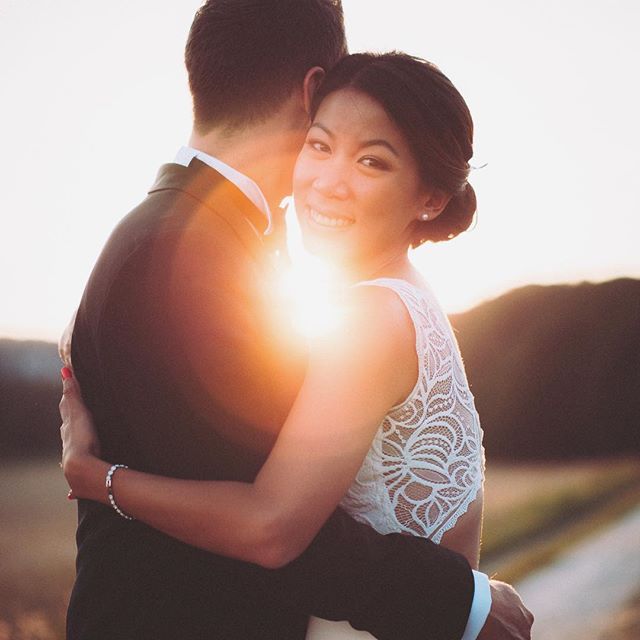 A bride and groom embrace in the sunset, sharing a tender moment of love on their wedding day. 