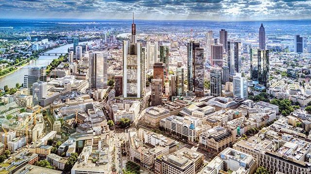 Aerial view of a modern city with tall skyscrapers under a cloudy sky.