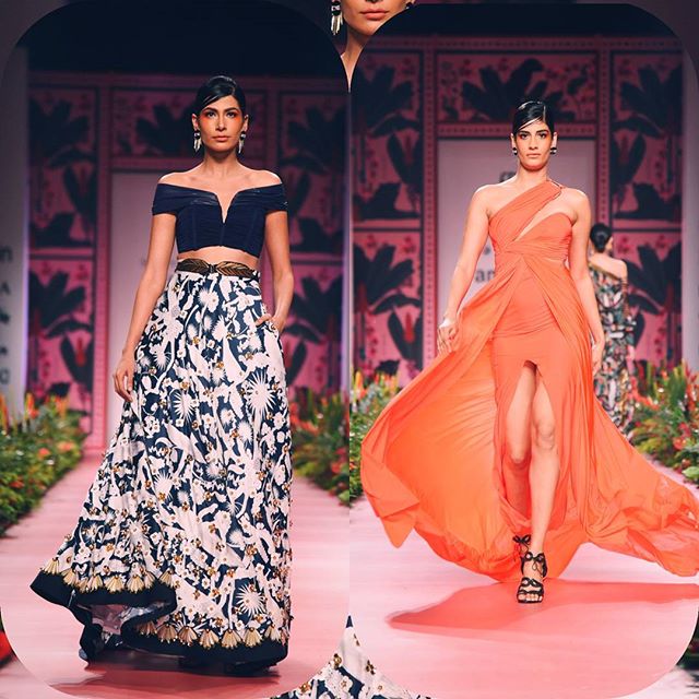 Two models walk the runway in designer fashion during a fashion show.