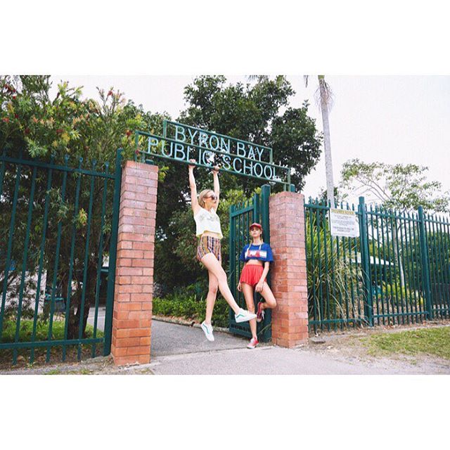 Two young women playfully pose at the entrance of Byron Bay Public School.
