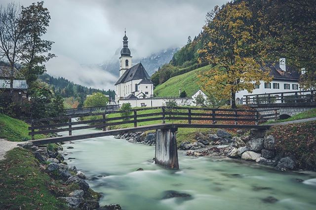 A picturesque European church and bridge create a serene landscape, perfect for travel and tourism promotions.