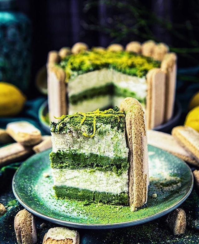 A slice of matcha cake decorated with ladyfingers, perfect for dessert lovers and bakers.