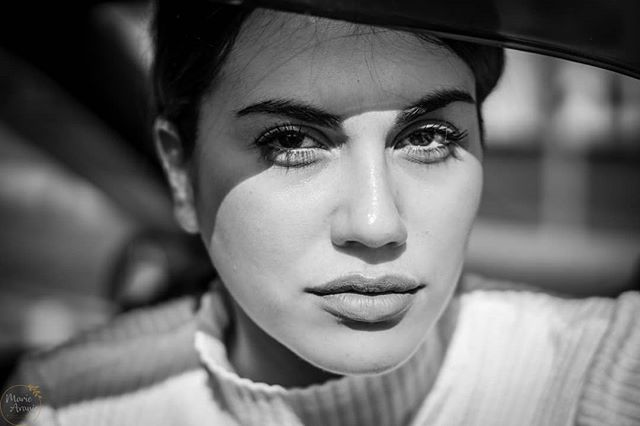 A striking black and white portrait of a woman with an intense gaze.