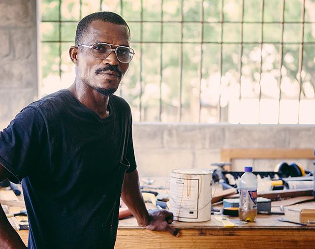 Portrait of a craftsman in his workshop, surrounded by tools and materials.