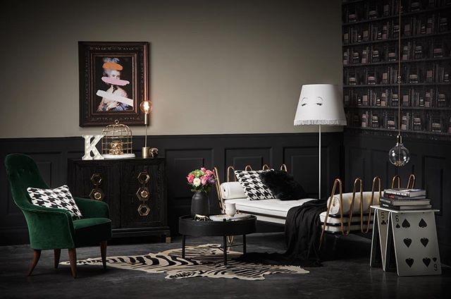 Eclectic living room features a green armchair, daybed, and unique decor in a stylish interior setting.