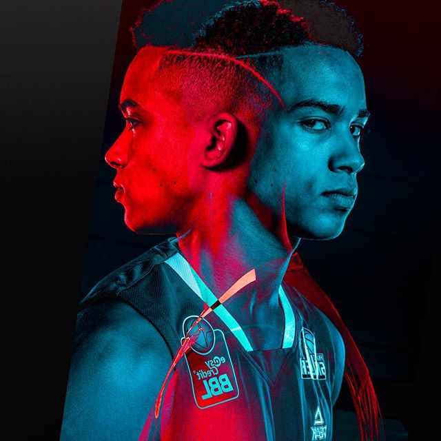A striking portrait of a basketball player with a dual-toned lighting effect, highlighting athleticism and determination.