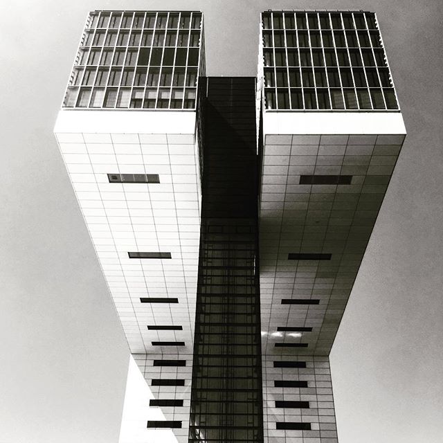 A striking low-angle monochrome shot of modern architecture featuring the iconic Crane Houses in Cologne.