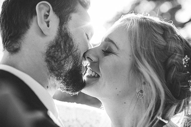 A bride and groom share an intimate moment in black and white on their wedding day, showcasing love and commitment.