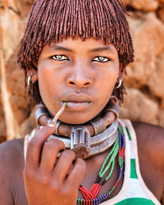 A portrait of a young woman with traditional Hamer tribe jewelry, showcasing cultural beauty and heritage.