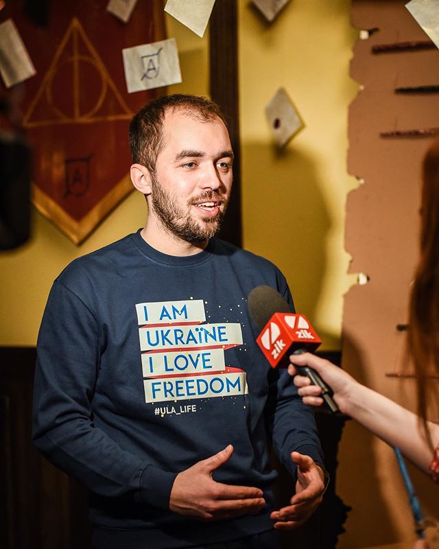 Man wearing an 'I am Ukraine I love freedom' sweater being interviewed with a zik microphone.