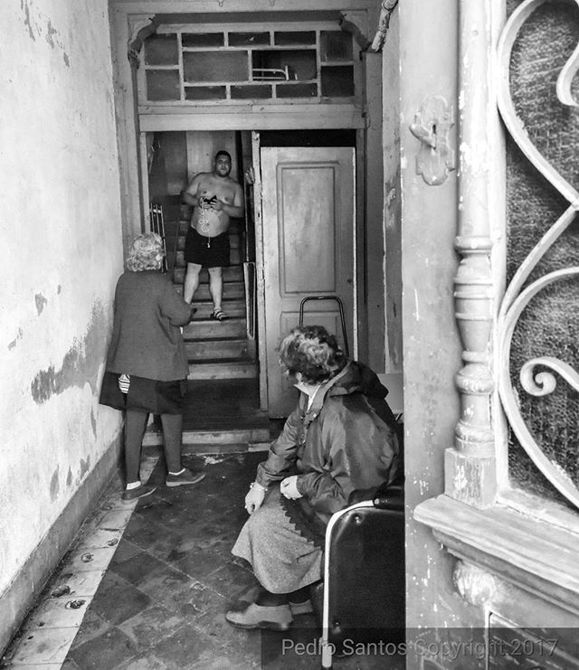 A black and white shot of people inside a building hallway.