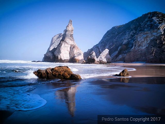 Scenic beach with rock formations and waves creates a tranquil coastal landscape.