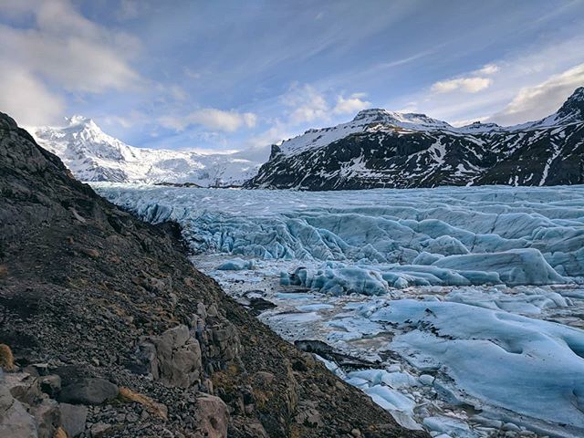 Vatnajökull glacier in Iceland, surrounded by snow-capped mountains under a cloudy sky. A serene and tranquil landscape.
