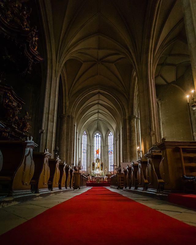 Grand church interior featuring a red carpet leading to the altar, showcasing architectural beauty and religious significance.