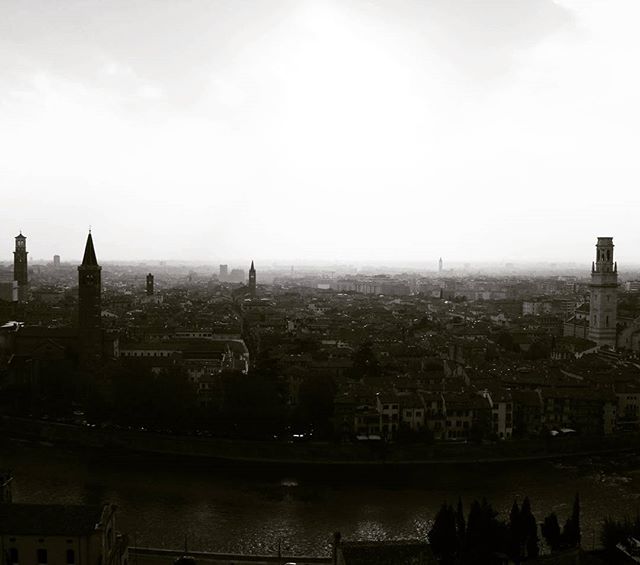 Monochrome cityscape view of Verona, Italy featuring historic buildings and a river.