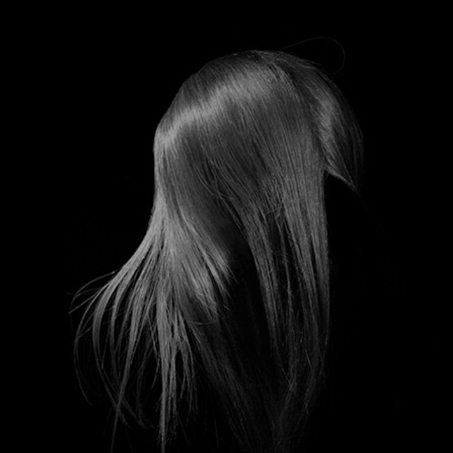 Elegant long brunette hair on a black background. Perfect for beauty, fashion, and hair care concepts.