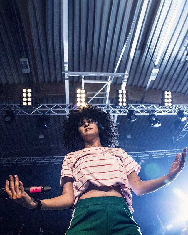 A singer performs on stage under bright lights, delivering a captivating live performance.