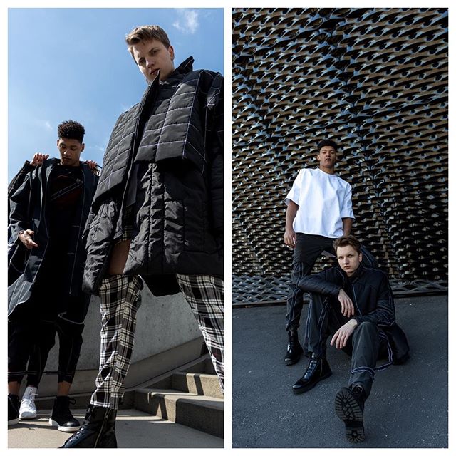 Editorial fashion shot of three male models in modern streetwear posing outdoors in urban setting.
