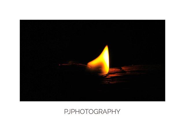 A matchstick flame burns brightly in the dark, creating a warm and intense light.