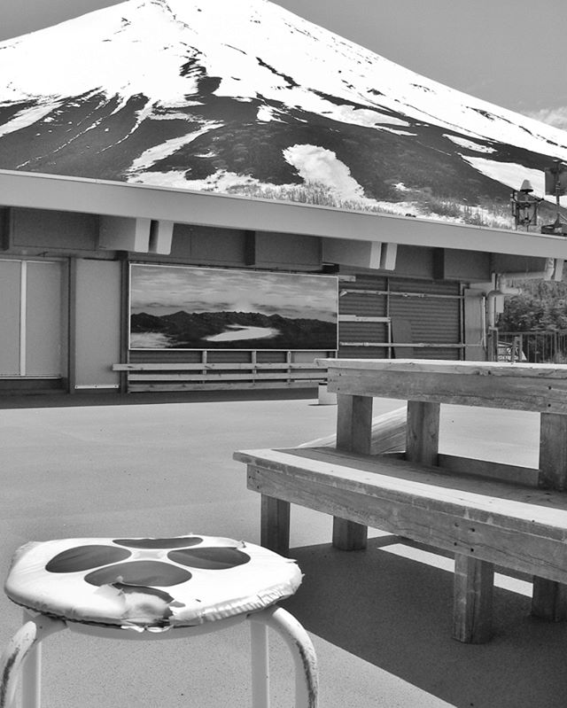 A black and white rooftop image shows seating with a mountain scene backdrop, suitable for urban design or travel campaigns.