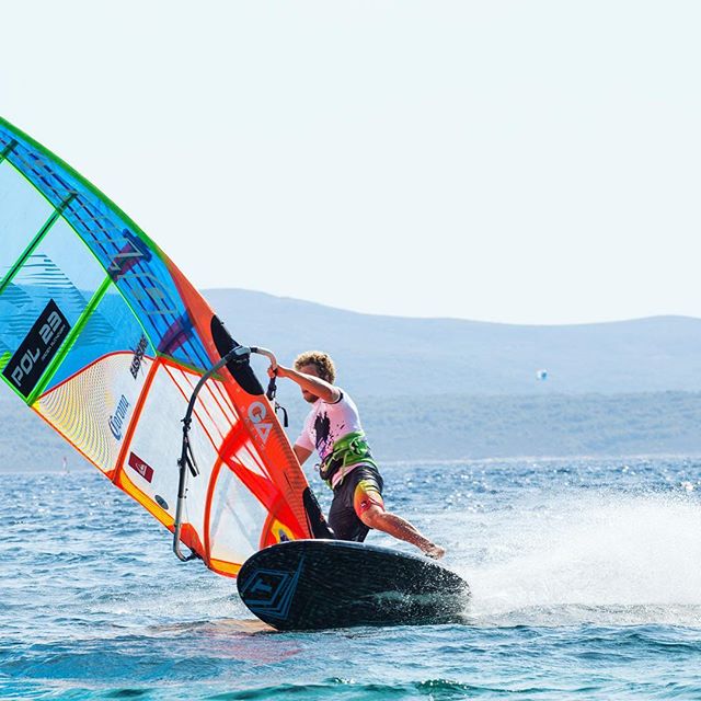 A windsurfer in action on the water, showcasing an energetic and dynamic sports scene.