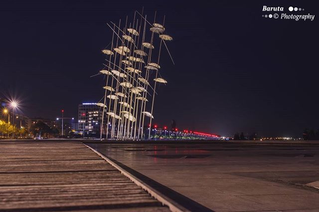Night view of the Umbrellas sculpture in Thessaloniki, Greece, creating a serene urban scene.
