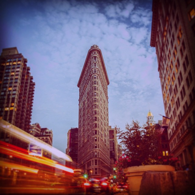 The iconic Flatiron Building in New York City stands tall against a cloudy sky in this cityscape, showcasing urban architecture.