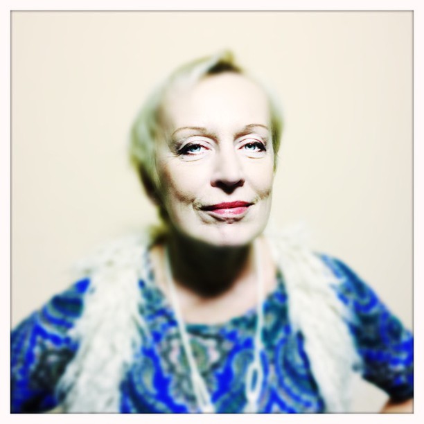 A portrait of a mature woman with a gentle smile and soft lighting.